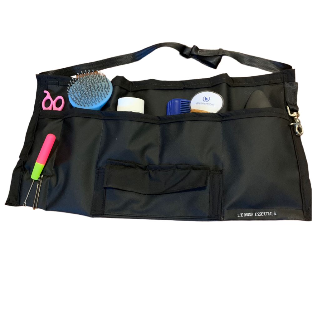 Black grooming apron with various tools on a white background