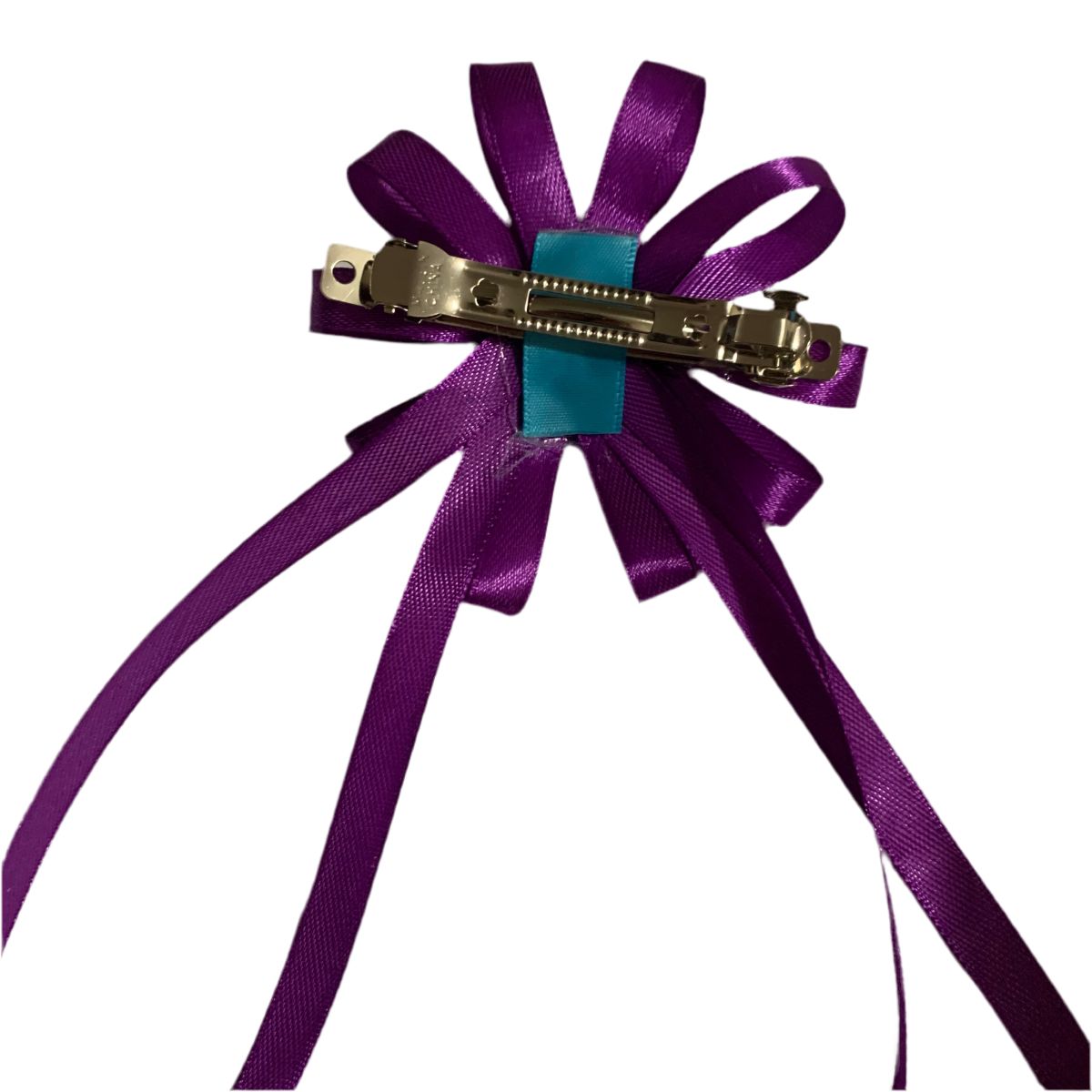 Purple ribbon bow with a silver clip on a white background