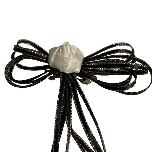 Hair bow made of black ribbons with a white center on a white background