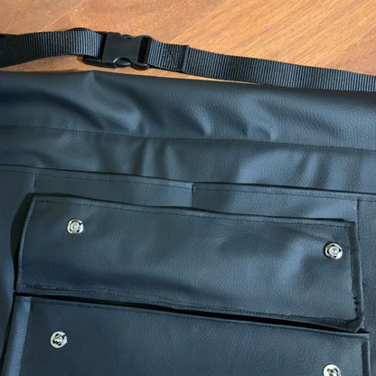 Close-up of a braiding apron with a black strap on a wooden surface