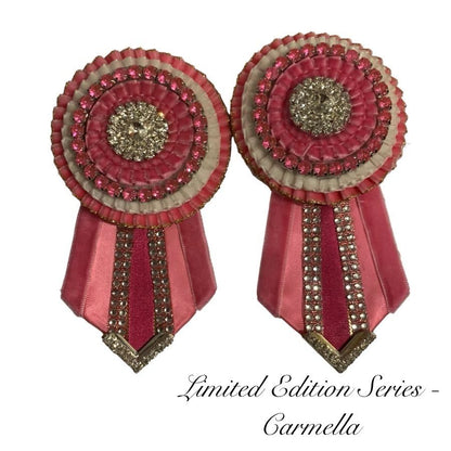 Pair of decorative rosettes with pink ribbons and white accents on a white background.