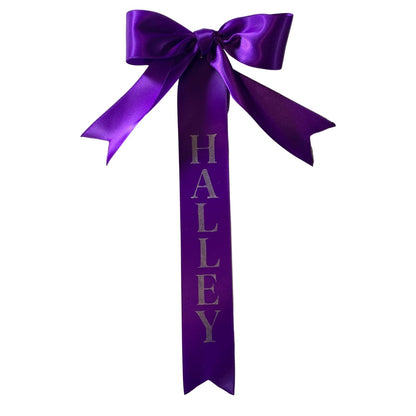 Purple custom tail bow with the name 'Halley' on a white background