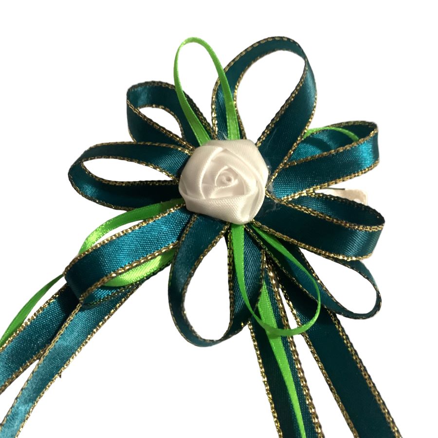 Decorative hair bow with green ribbons and a white rose on a white background