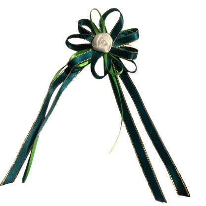 Decorative bow with green ribbons and a white center on a white background
