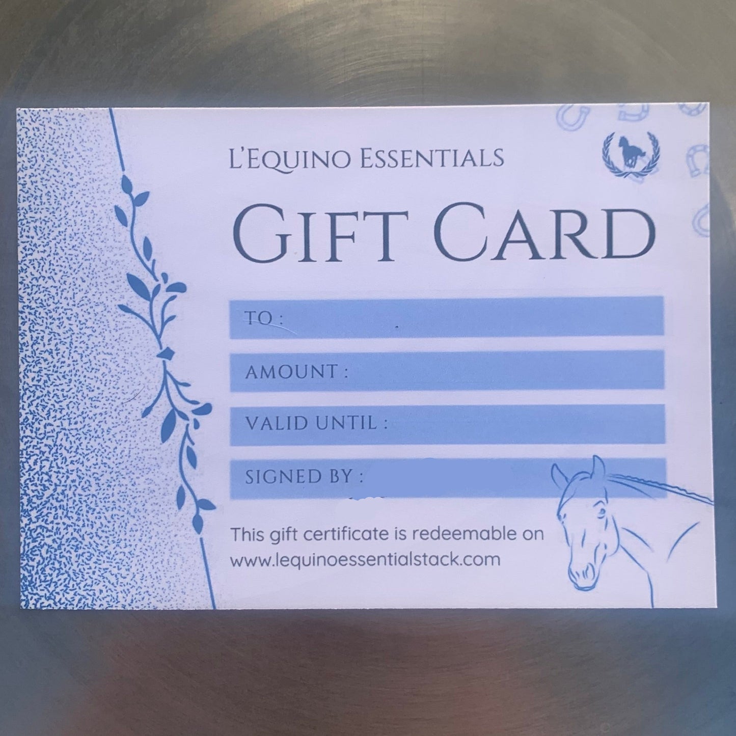 L'Equino Essentials gift card with horse illustration on a reflective surface