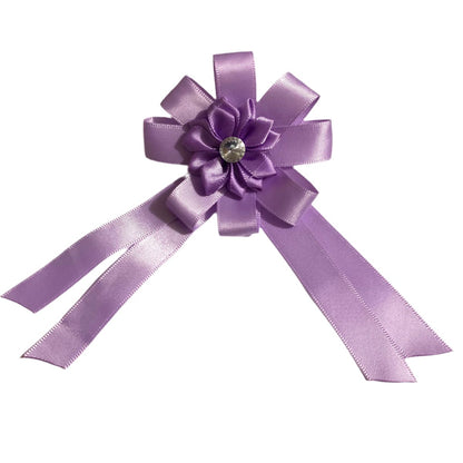 Purple equestrian hair bow with a flower and gemstone on a white background