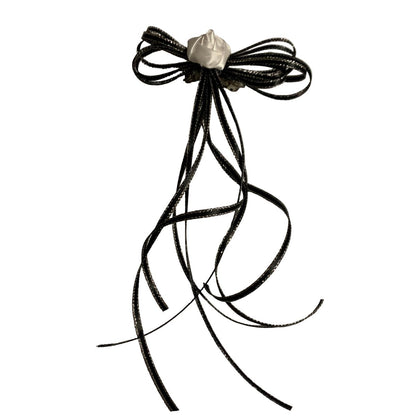 Black hair bow with a white flower on a white background