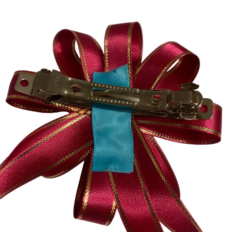Pink hair bow featuring a metal clip on a white background.