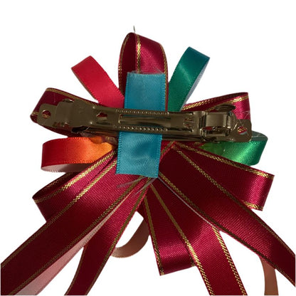 Colorful ribbon hair clip with red, green, and blue ribbons on a white background