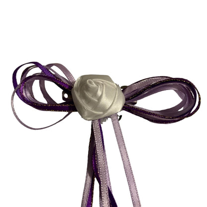 Decorative hair bow with a white rose center on a white background