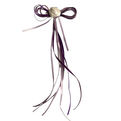 Purple hair bow with ribbons on a white background