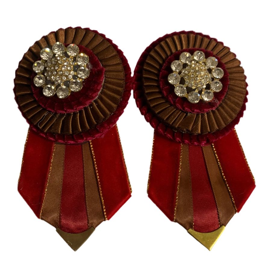 Pair of decorative removable rosettes with red and brown colors and gemstone center on a white background