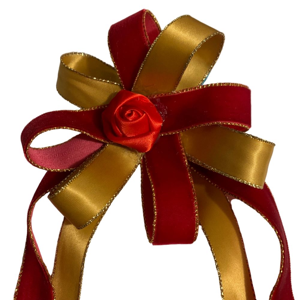 Red and gold ribbon hair bow with a red rose on a white background made by L'Equino Essentials