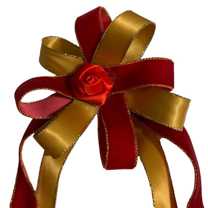 Red and gold ribbon hair bow with a red rose on a white background made by L'Equino Essentials