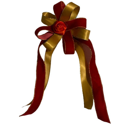 Red and gold ribbon hair bow with a rose on a white background