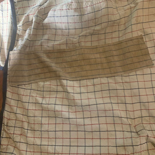 Summer rug with red, black, and white lines on a beige background after repair