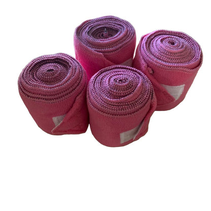 Four rolls of pink polo wraps on a white background